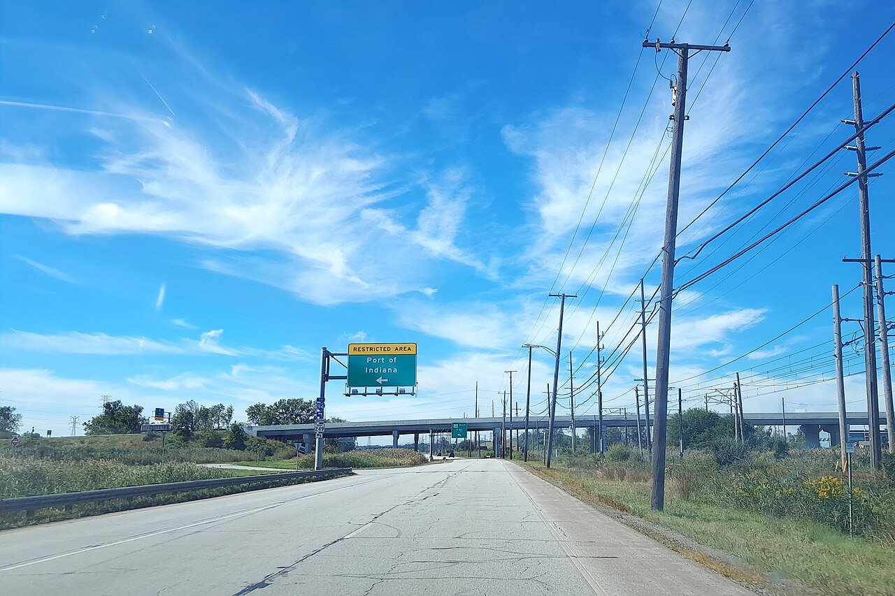 Overhead sign on U.S. 12 westbound in Portage directing traffic left to the restricted Port of Indiana access road