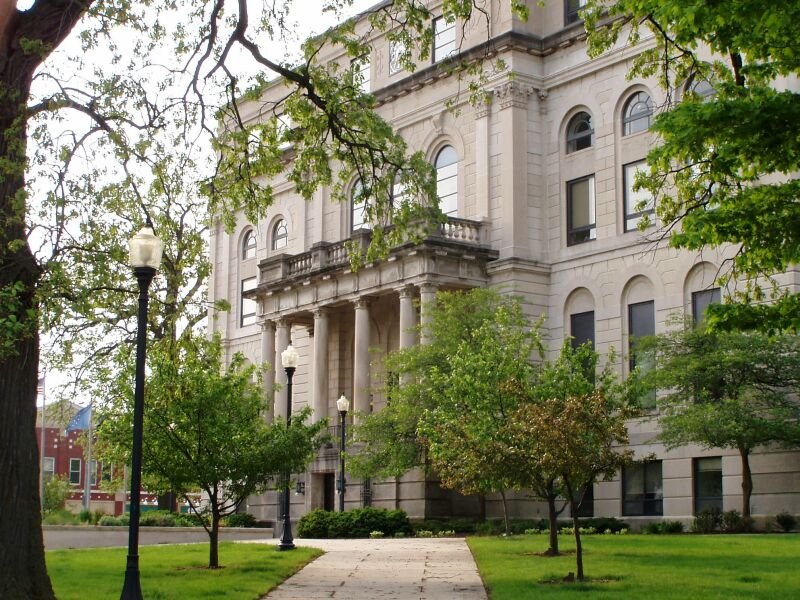North facade of the Porter County Courthouse in downtown Valparaiso, framed by trees.