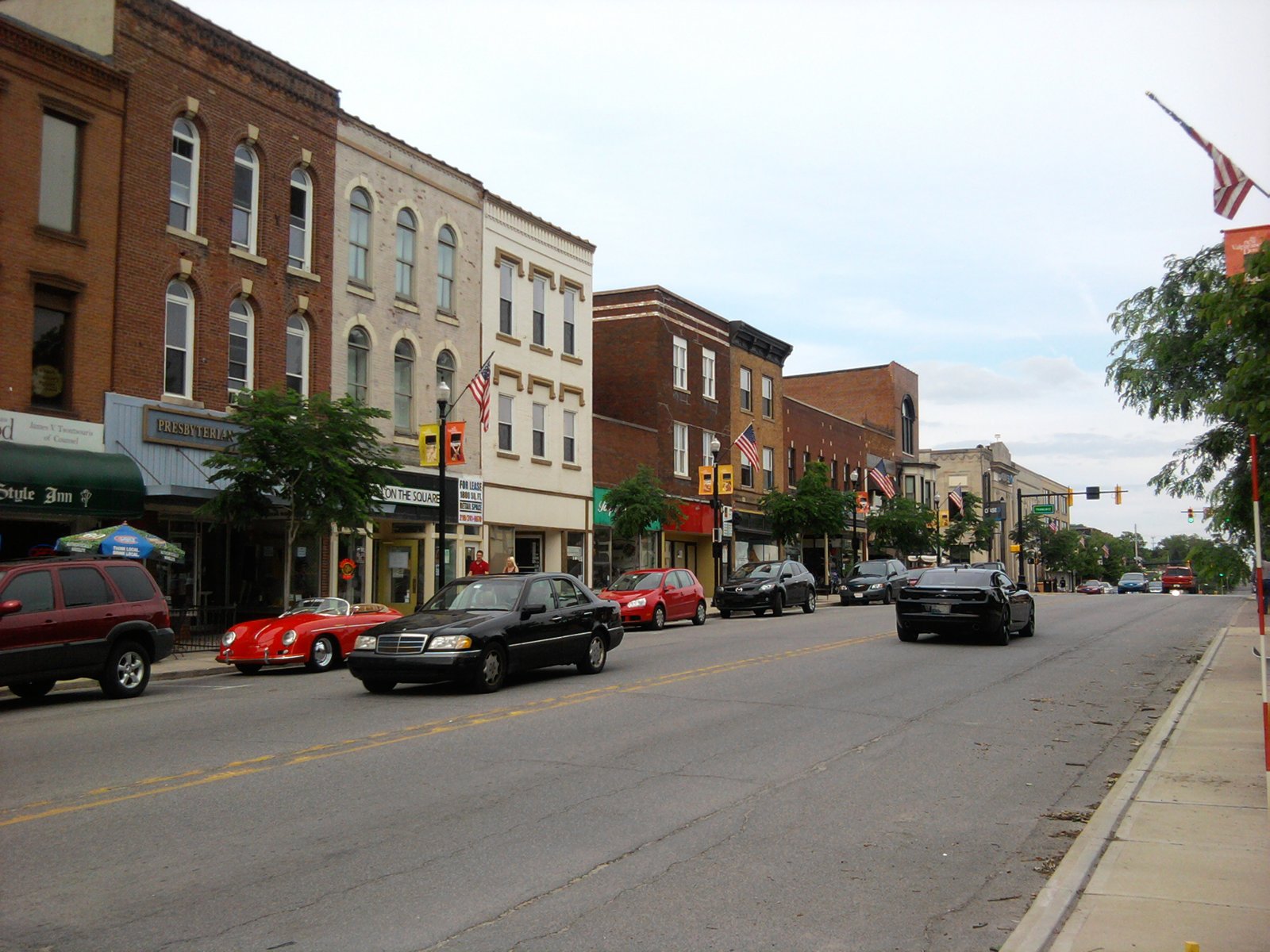 Lincolnway streetscape in downtown Valparaiso with storefronts and parked cars under an overcast sky