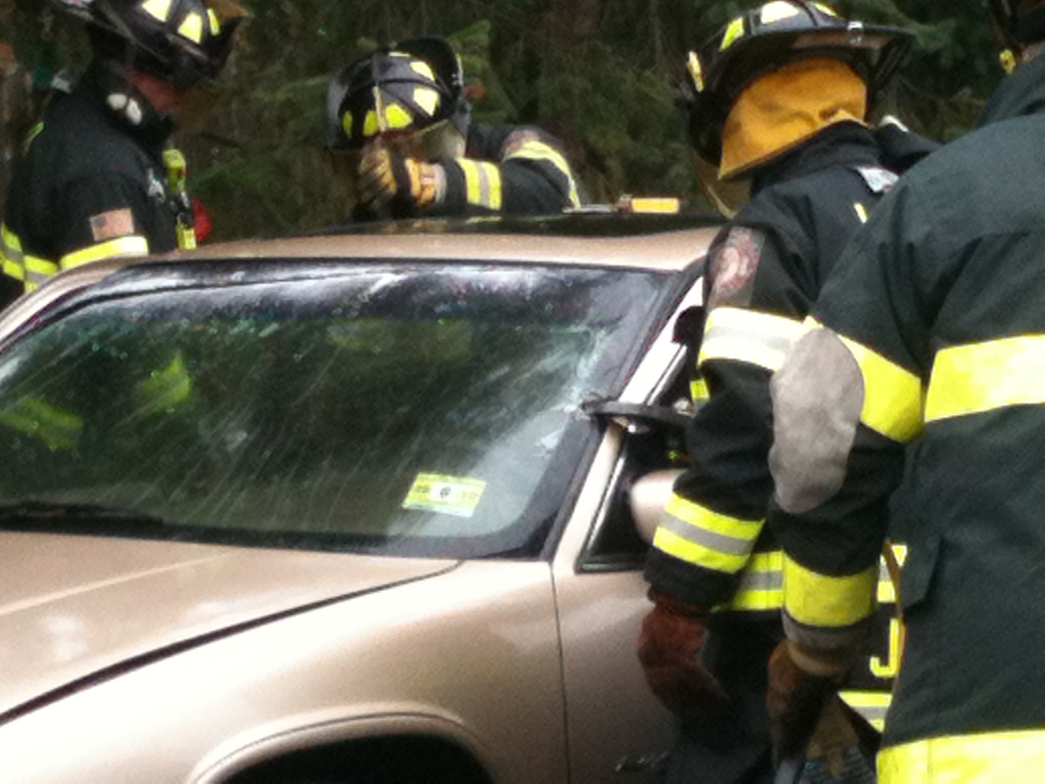 Firefighters practice vehicle extrication on a training car.