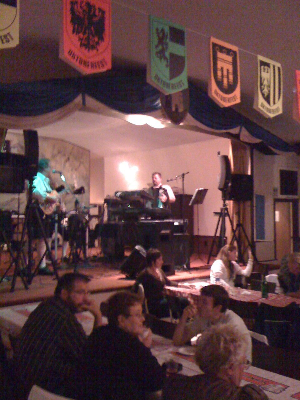 Oktoberfest hall crowd and stage band (illustrative file photo; Commons title: Oktoberfest polka band).